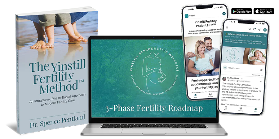 A book, laptop, and smartphones showcasing fertility resources and services, highlighting an integrated approach to modern fertility care.